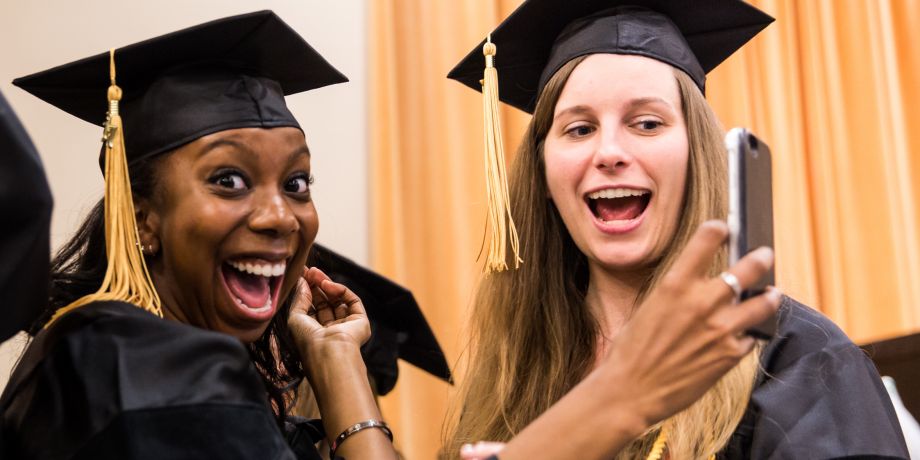happy graduates take a selfie during commencement