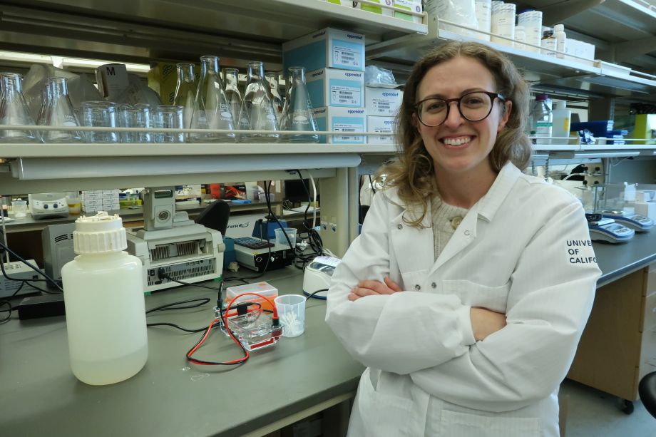 Zaro in white coat with lab equipment