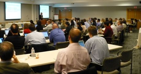 speaker addresses large room of participants.