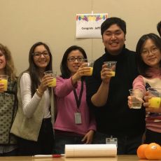 group toasts Jeffrey with orange juice.