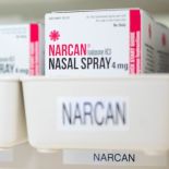 Boxes of Narcan are shown on a shelf in a pharmacy.