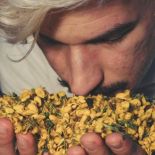 A man smelling a bundle of flowers in his hands