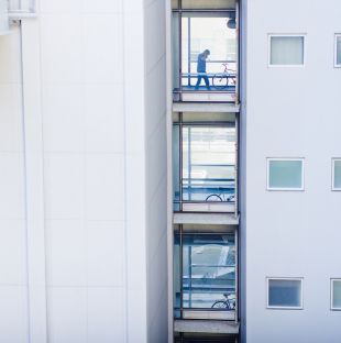 person crossing pedestrian bridge between buildings
