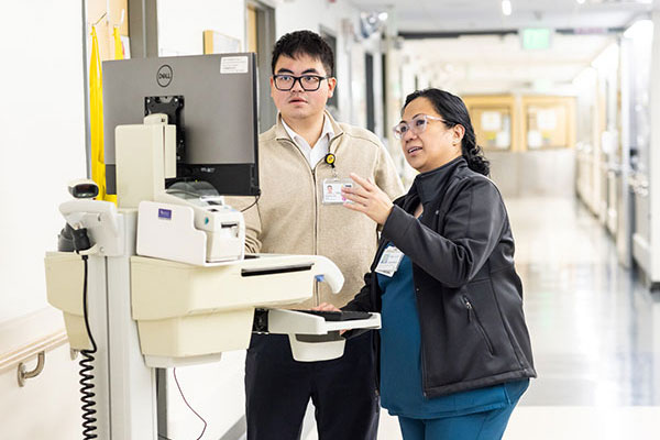 two people at a computer monitor in a hospital setting