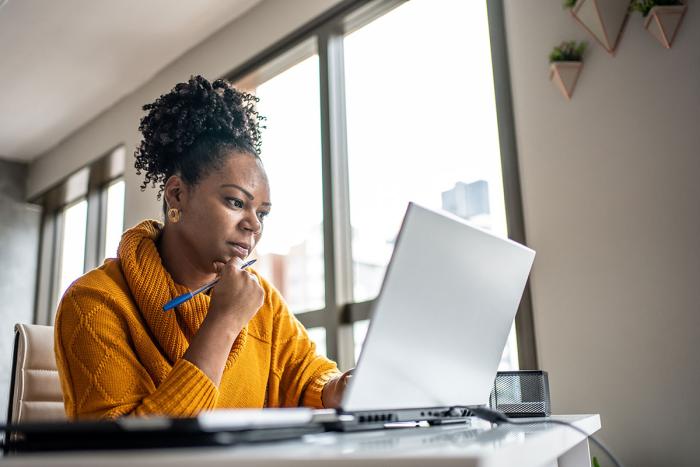 woman focused looking at laptop screen